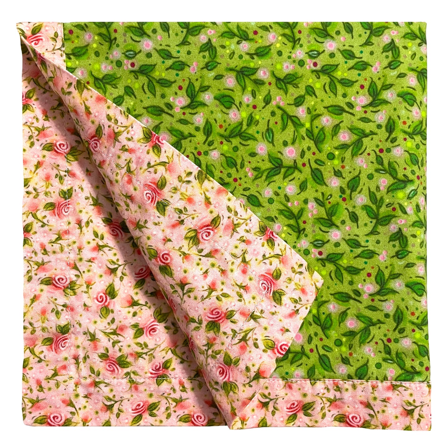 2-color reversible cloth napkin quarter-folded showing back pink mini tea roses design and front green leaves design with pink mini tea roses border.