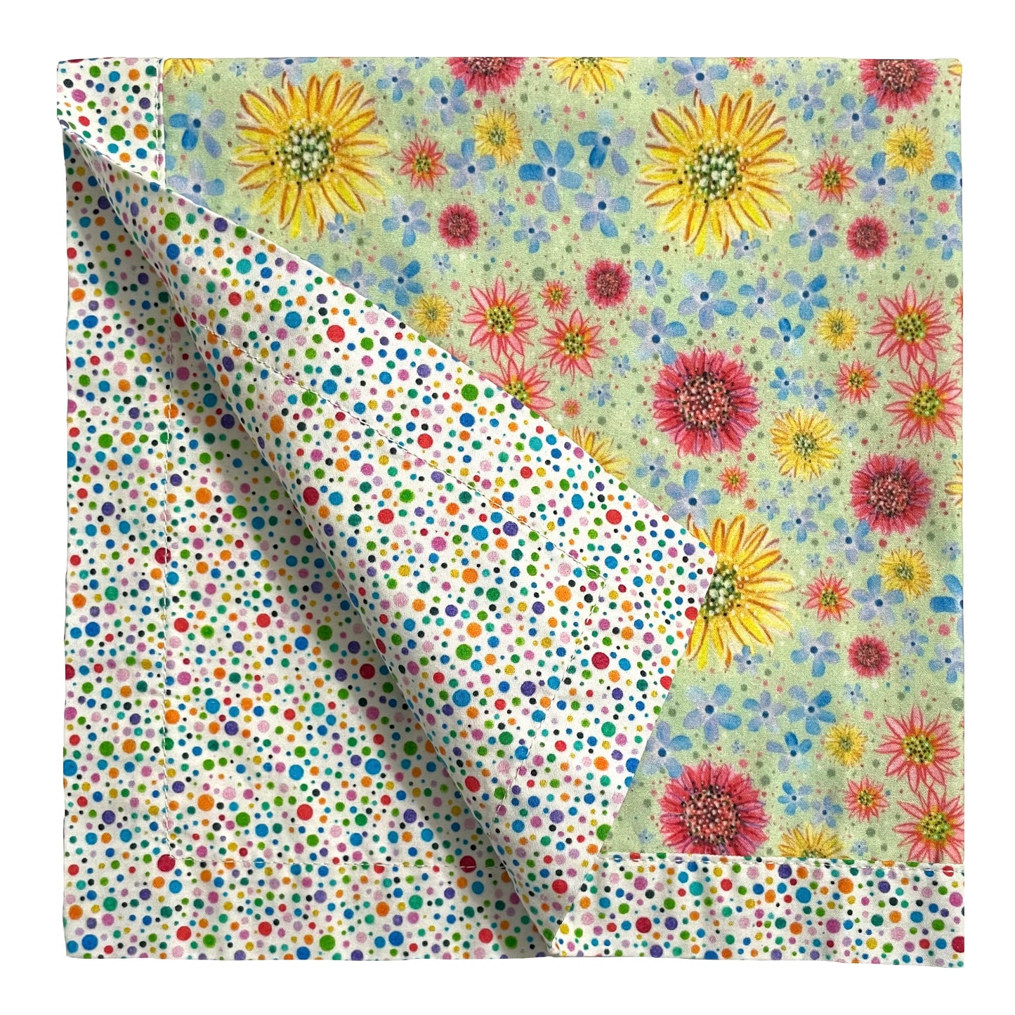 2-color reversible cloth napkin quarter-folded showing back multicolor polka dots design and front wildflowers design with multicolor polka dots border.