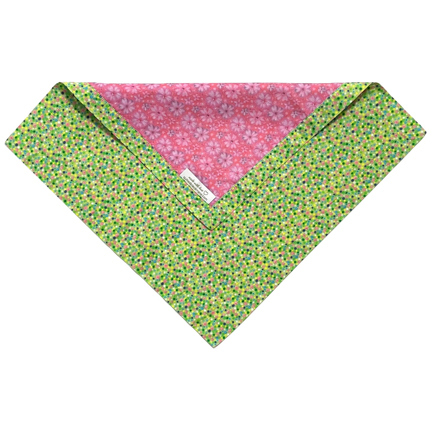 Folded edge of pink floral and green polka dots cloth napkin.