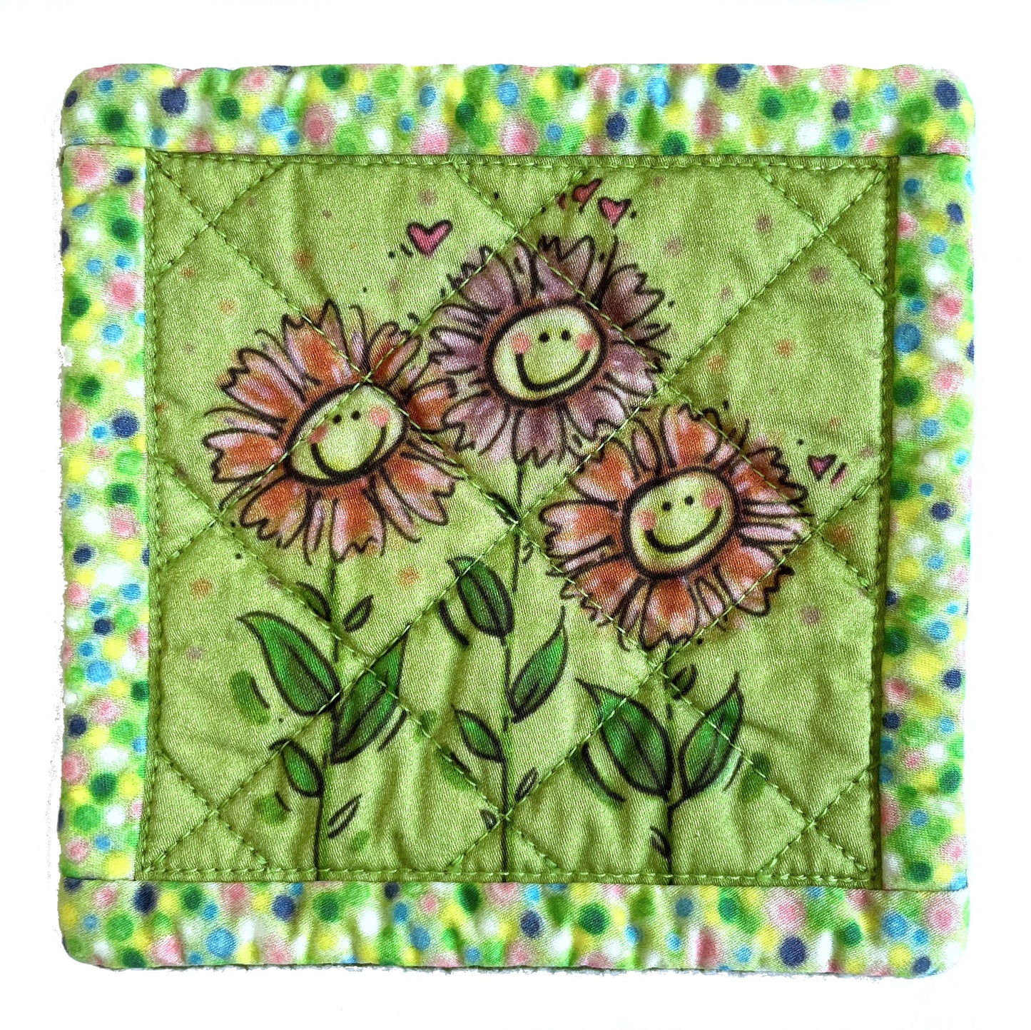 Square quilted mug mat coaster in avocado green with smiling flowers design and polka dot border.