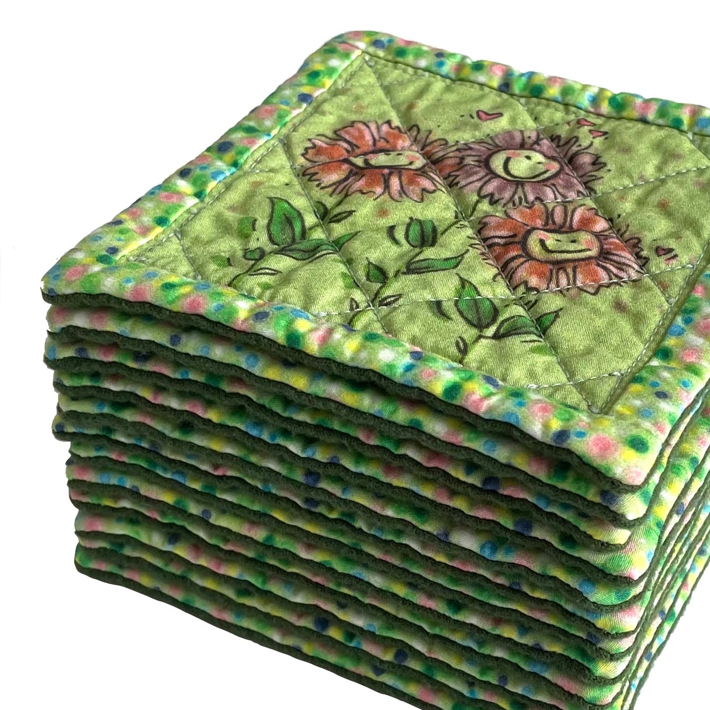 Stack of quilted mug mats, mini mats, saucer mats, coasters in green with smiling flowers.