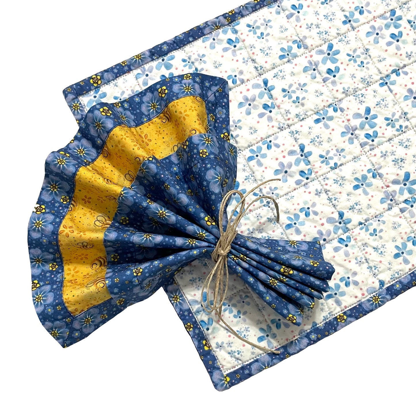 Quilted placemat rectangle periwinkles design and cloth napkin on top with blue floral and yellow bees design in fan fold.